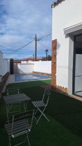 a yard with two chairs and a swimming pool at El Antiguo Corral de Sevilla in Navalcán