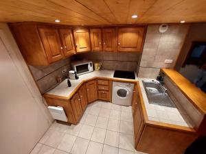 Cosy Duplex Arc1800 Aiguille Grive1 6 personnes في آرك 1800: مطبخ صغير مع غسالة ملابس وميكرويف