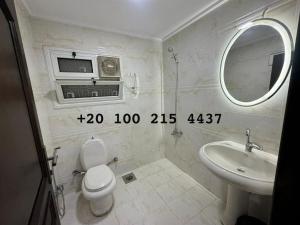 a bathroom with a sink and a toilet and a mirror at شقه 103 سوبر لوكس فيو قناه السويس والبحر in Port Said