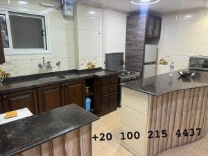 a large kitchen with wooden cabinets and a counter top at شقه 103 سوبر لوكس فيو قناه السويس والبحر in Port Said