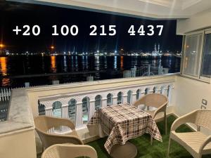 a balcony with a table and chairs and a view of the water at شقه 103 سوبر لوكس فيو قناه السويس والبحر in Port Said