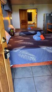 un grupo de tres camas en una habitación en Willy's Fish Camp Hillside Sea View Rooms, en Drake