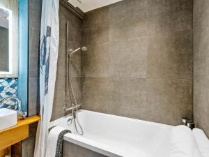 a bathroom with a bath tub and a sink at Beautiful studio - private garden, EV, breakfast - Chalet Hug studio in Arzier +27 photos