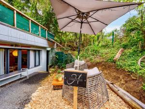 a table with an umbrella in front of a building at Beautiful studio - private garden, EV, breakfast - Chalet Hug studio in Arzier