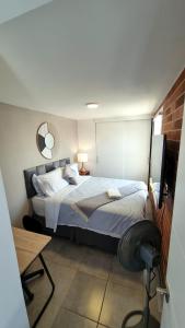 危地马拉Nuevo y Moderno Apartamento con Parqueo en la atractiva Zona 4的一间卧室配有一张带镜子的床和一张书桌