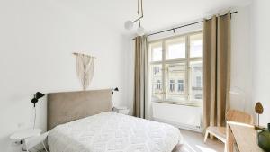 a white bedroom with a bed and a window at Designer Touch 2-bedroom in Picturesque Area in Golčŭv Jeníkov