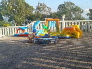 due bambini seduti in gonfiabili in un parco giochi di Appartamento Privato Adriatica a Lesina