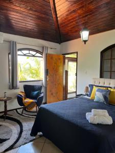 a bedroom with a blue bed and a chair at Portal de Búzios in Armacao dos Buzios +93 photos