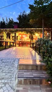 un patio con tavolo, panche e luci di maderedocevida a Boaventura