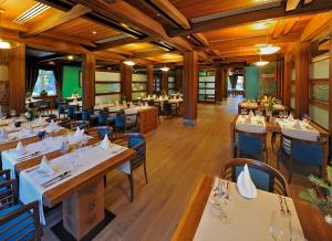 a restaurant with wooden floors and tables and chairs at Hotel Zochova Chata - Adult friendly in Modra
