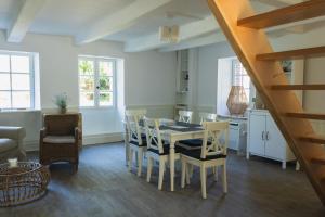 una cucina e una sala da pranzo con tavolo e sedie di Ty pesker a Jouvente