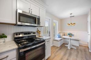 a kitchen with a stove and a microwave at Beachside Blast Off Stylish Cape Canaveral Townhome Near Surf & Space in Cape Canaveral
