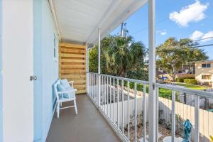 a balcony with a white chair and a window at Beachside Blast Off Stylish Cape Canaveral Townhome Near Surf & Space in Cape Canaveral