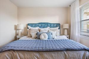 a bedroom with a large bed with a blue headboard at Beachside Blast Off Stylish Cape Canaveral Townhome Near Surf & Space in Cape Canaveral +22 photos