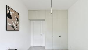 a white room with a white cabinet and a painting at Designer Touch 2-bedroom in Picturesque Area in Golčŭv Jeníkov