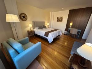 瓦拉斯Habitaciones La Casona的一间带床和蓝色沙发的酒店房间 更多21张照片