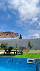 two chairs and an umbrella next to a pool at Maison avec piscine pour famille au région de safi in Safi
