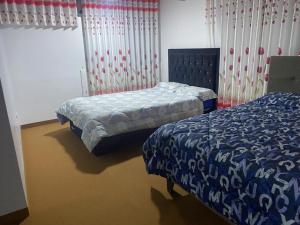 VICTORIA HOUSE - Huancayo - Hualhuas في Hualhuas: غرفة نوم بها سريرين ونافذة