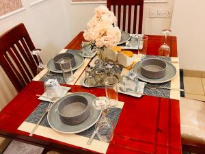 a red table with plates and glasses on it at Comfy cozy in Kira