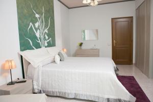 - une chambre avec un lit blanc et une peinture murale dans l'établissement B&B The Queen, à Ispica