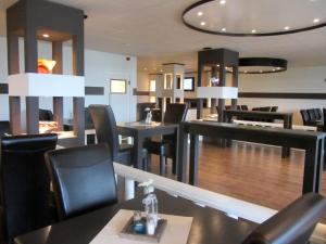 un restaurante con mesas y sillas negras y un comedor en De Rozenborg, en Scharmer