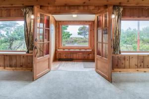 an empty room with wooden walls and windows at The Tides in Seaside