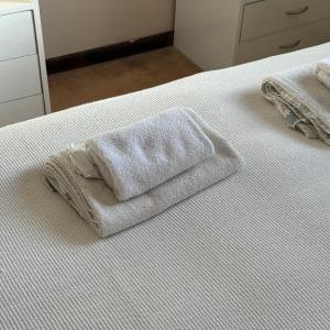 a white towel sitting on top of a bed at Geko Apart Hotel in Mar del Plata