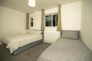 En eller flere senge i et værelse på Modern 3 Bedroom Home Ideal for Families and Business Stays