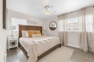 een slaapkamer met een bed en een plafondventilator bij Cocoa Beach 3BR Oasis - 1 Block To Beach in Cape Canaveral