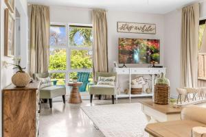 een woonkamer met een bank en een tv bij Cocoa Beach 3BR Oasis - 1 Block To Beach in Cape Canaveral