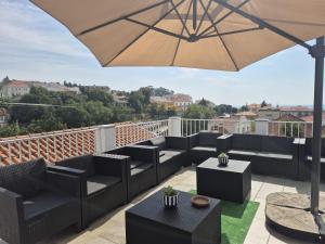 a patio with couches and an umbrella on a balcony at Blue Castle House in Gouveia