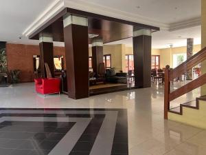 un vestíbulo con una silla roja en un edificio en NOVA Hotel Pinamar, en Pinamar 6 fotos más