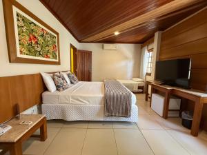 a bedroom with a bed and a flat screen tv at Hotel Mar de Cabo Frio in Cabo Frio