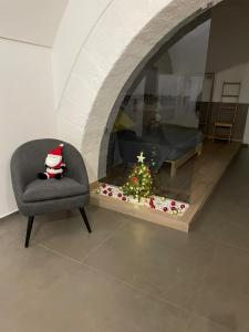 a chair and a christmas tree in a room at Archome Luxury Apartment in Brindisi