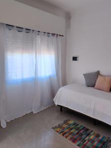 een slaapkamer met een bed en een wit gordijn bij Departamentos Catamarca in La Porteña