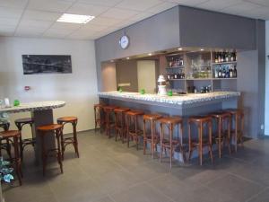 a bar with wooden stools in a room at De Rozenborg in Scharmer