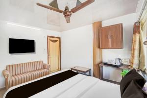 艾哈迈达巴德Super Collection O Maninagar East Formerly Maninagar Residency的一间带床、电视和沙发的卧室 更多22张照片