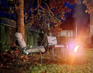 MotungararaCasa de los Tūi的两个椅子和一个晚上院子里的火坑