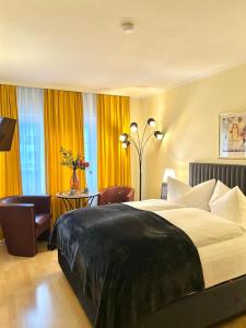 ein Hotelzimmer mit einem großen Bett und einem Tisch in der Unterkunft The Soho Altstadt Relais in Düsseldorf
