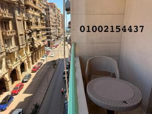 a table on the balcony of a building with a street at شقه 401عائليه سوبر لوكس في وسط الحي الافرنجي في مركز المدينه in Port Said