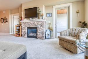 a living room with a fireplace with a tv above it at Rivers Edge at Bridgeport in Seaside