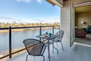 a table and chairs on a balcony with a view of the water at Rivers Edge at Bridgeport in Seaside