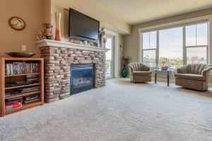 a living room with a stone fireplace with a flat screen tv at Rivers Edge at Bridgeport in Seaside