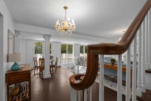 un escalier dans un salon avec un lustre dans l'établissement Pacific Way Villa, à Gearhart