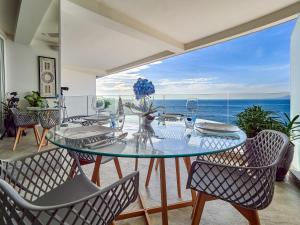 a dining room with a table and chairs and the ocean at Maxwell Residences at Indah in Puerto Vallarta