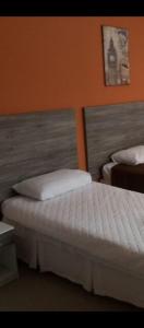 リオ・グランデにあるMusleh pousadaのオレンジ色の壁の寝室にベッドが2つある