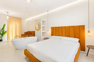 a bedroom with a large bed and a bath tub at Sofì Luxury Suite in Iglesias