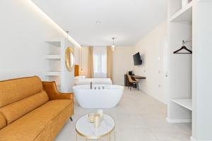 een woonkamer met een bank en een ligbad bij Sofì Luxury Suite in Iglesias