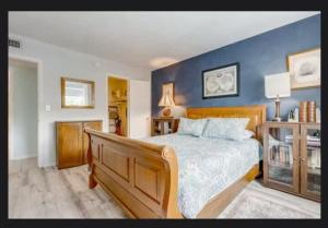 una camera da letto con un letto grande con una parete blu di Cape Canaveral Condo Steps from the Beach a Cape Canaveral