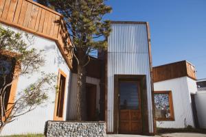 a house with a tree in front of it at EcoHotelTDF in Río Grande